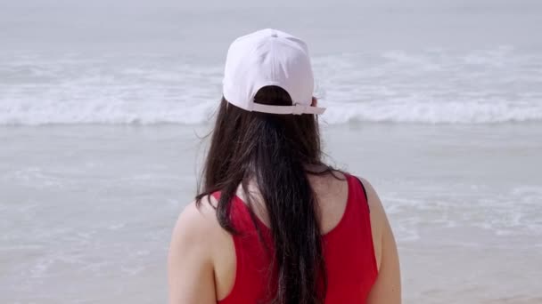 Молода жінка відпочиває на пляжі під час літніх канікул — стокове відео