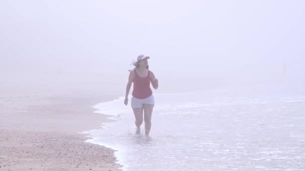 Giovane donna si rilassa sulla spiaggia durante le sue vacanze estive — Video Stock