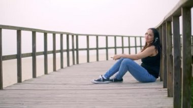 Genç bir kadın yaz tatili boyunca kumsalda dinleniyor. Yavaş çekim.