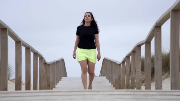 砂浜の上の桟橋を歩く スローモーションショット — ストック動画