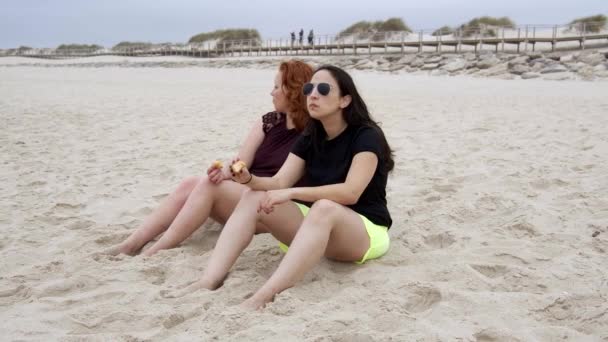 Las Mujeres Jóvenes Comen Rosquillas Playa Disparo Cámara Lenta — Vídeos de Stock