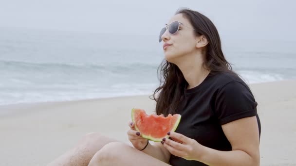 美丽的女人在海滩上吃西瓜 动作缓慢 — 图库视频影像
