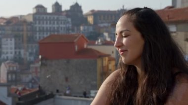 Porto tarihi kasabasının çatısında mutlu bir kadın. Seyahat görüntüleri.