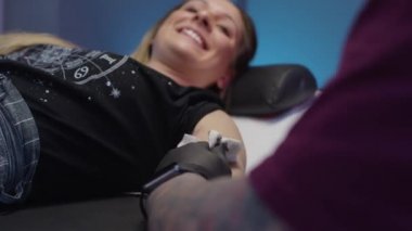 Güzel kızlar kolunda dövme yaptırır. Dövme ve piercing stüdyosu.