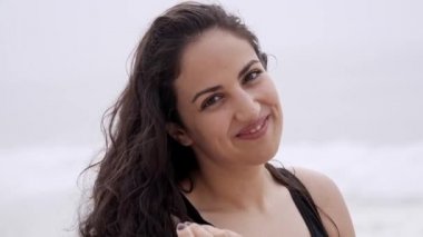 Genç bir kadın yaz tatili boyunca kumsalda dinleniyor. Yavaş çekim.