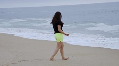 Güzel kız okyanus kıyısındaki sahilde eğleniyor - yaz tatili - yavaş çekim