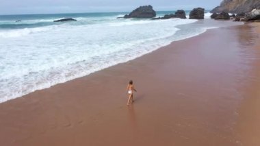 Cennet kumsalındaki seksi kadın yaz tatilinin tadını çıkarıyor. Hava aracı görüntüleri.