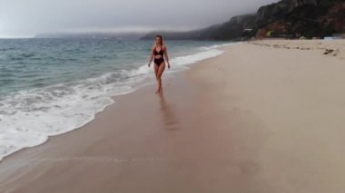 Plajda yaz tatili - Okyanusta tatlı bir kız - hava aracı görüntüsü