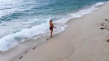 Plajda yaz tatili - Okyanusta tatlı bir kız - hava aracı görüntüsü