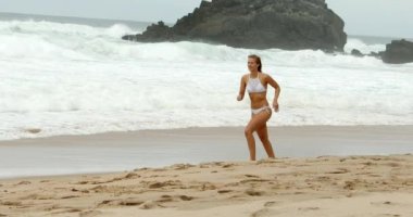 Genç ve seksi kadın Atlantik Okyanusu 'nun kumlu sahillerinde eğleniyor. Seyahat görüntüleri.