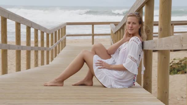 Όμορφη Γυναίκα Κάθεται Μια Ξύλινη Προβλήτα Στην Παραλία Ταξιδιωτικό Υλικό — Αρχείο Βίντεο