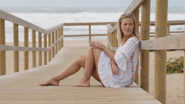 Όμορφη Γυναίκα Κάθεται Μια Ξύλινη Προβλήτα Στην Παραλία Ταξιδιωτικό Υλικό — Αρχείο Βίντεο