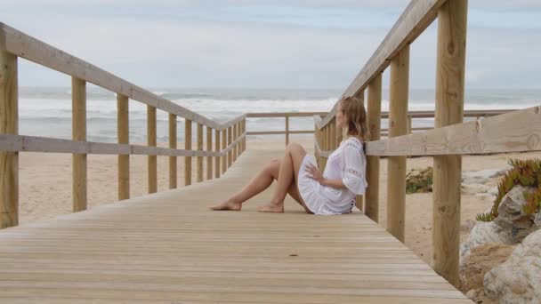 Ładna Kobieta Siedzi Drewnianym Molo Plaży Zdjęcia Podróży — Wideo stockowe