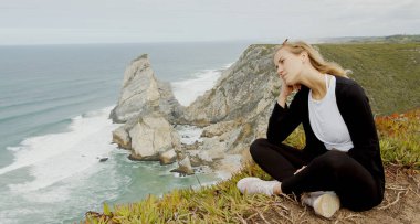 Sitting at the coast of Cabo da Roca in Portugal - travel photography clipart