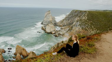 Sitting at the coast of Cabo da Roca in Portugal - travel photography clipart