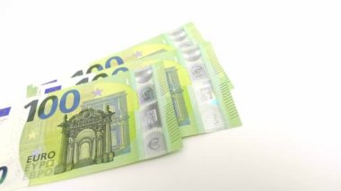 Bir deste 100 Euro 'luk banknotları masaya atmak. Yakın çekim.