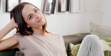 Genç bayan kanepede dinleniyor.