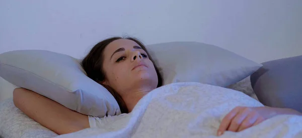 Красивая девушка лежит в постели — стоковое фото