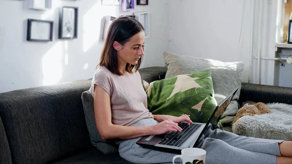 Молодая женщина работает в своем домашнем офисе со своим ноутбуком — стоковое фото