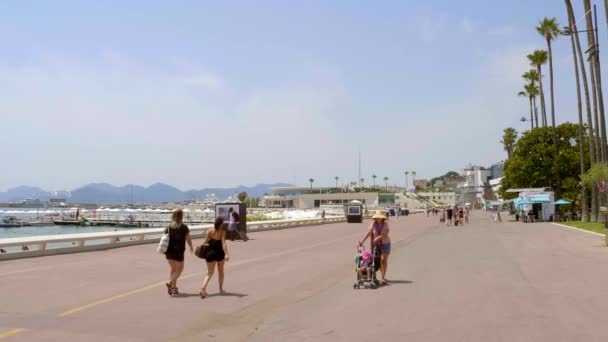 Människor promenader längs Croisette Promenade i Cannes - CITY of CANNES, Frankrike - JULI 12, 2020 — Stockvideo