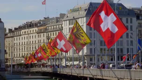 Banderas de Suiza y la ciudad de Ginebra en un puente en Ginebra - GINEBRA, SUIZA - 8 de JULIO de 2020 — Vídeo de stock