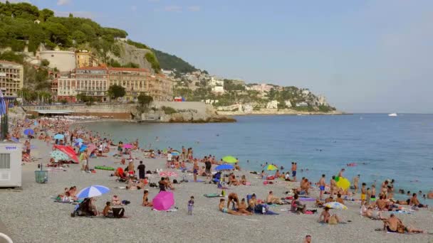 Pessoas tomando banho de sol na praia de Nice - CIDADE DE NICE, FRANÇA - JULHO 10, 2020 — Vídeo de Stock