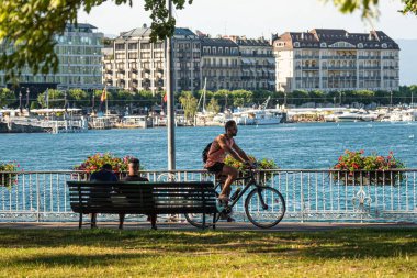Riding a bike in Geneva in Switzerland - CITY OF GENEVA, SWITZERLAND - JULY 8, 2020 clipart