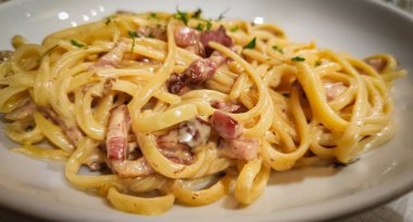 Beyaz tabakta spagetti Carbonara. Yemek fotoğrafçılığı.