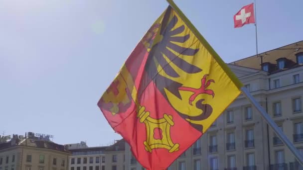 Vlaggen van Zwitserland en de stad Genève op een brug in Genève - GENEVA, ZWITSERLAND - 8 JULI 2020 — Stockvideo