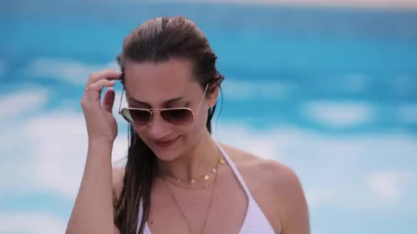 Portrait of a young pretty woman by a swimming pool — Stock Video
