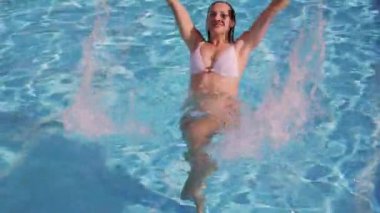 Bikinili seksi kız havuzda eğleniyor.
