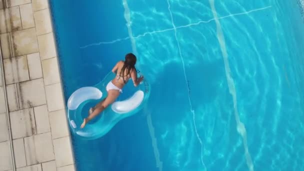 Pretty woman jumps from a mattress in a swimming pool — Stock Video