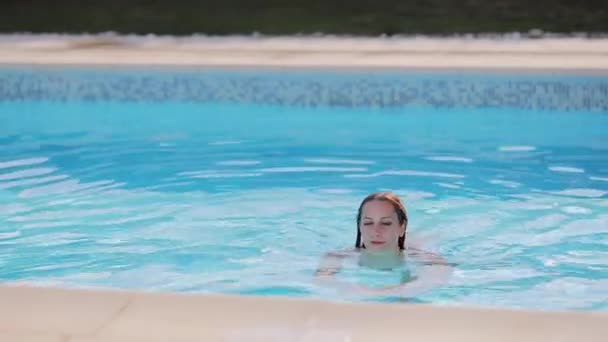 Mujer bonita y sexy en bikini en una piscina — Vídeos de Stock