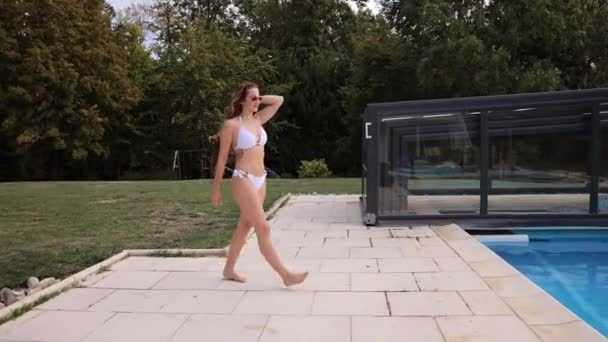 Hübsches und sexy Mädchen setzt sich an einen Pool — Stockvideo