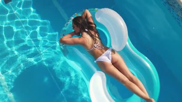 Ragazza sexy gode il sole nell'acqua cristallina di una piscina — Video Stock