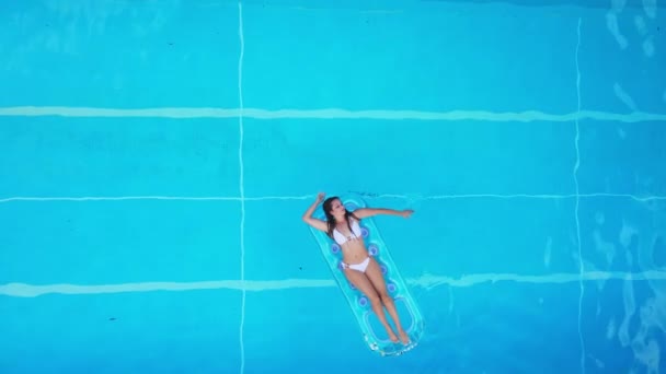 Hübsches Mädchen liegt auf Luftmatratze im Schwimmbad — Stockvideo