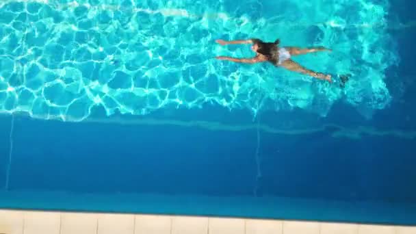 Young woman enjoys swimming in the cool water of a pool in summertime — Stock Video