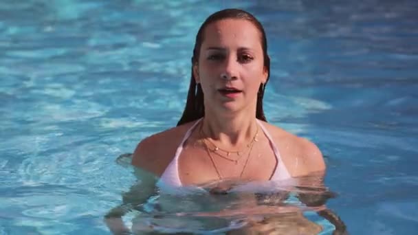 Menina sexy em biquíni tem diversão na piscina — Vídeo de Stock