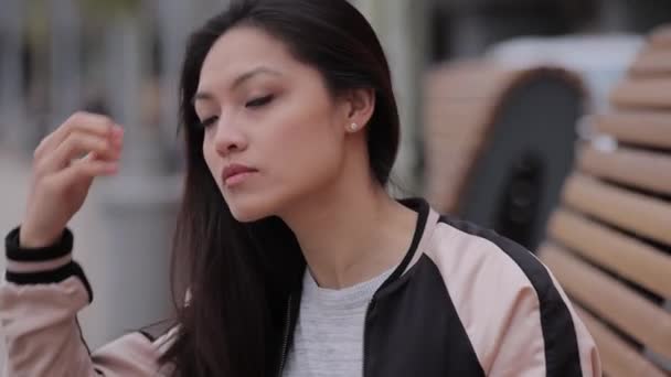 Young Asian woman poses for the camera in an urban area — Stock Video