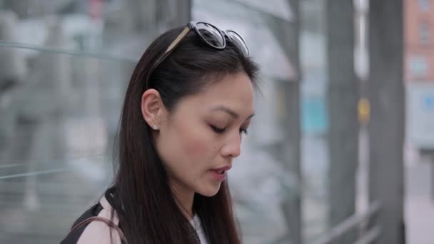 Giovane donna asiatica scrive messaggi di testo sul suo telefono — Video Stock