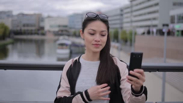 Junge Asiatin macht Selfie im Stadtgebiet — Stockvideo