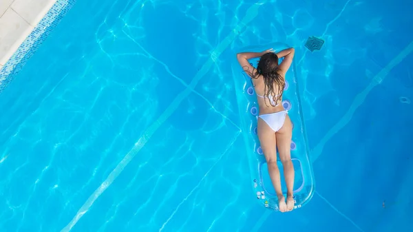 Sexig flicka njuter av solen i det kristallklara vattnet i en pool — Stockfoto