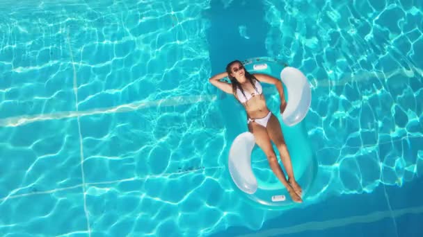 Красивая девушка лежит на надувном матрасе в бассейне — стоковое видео