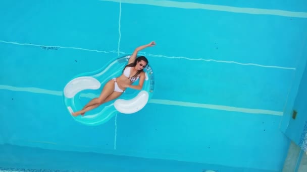 Jolie fille se trouve sur un matelas gonflable dans la piscine — Video