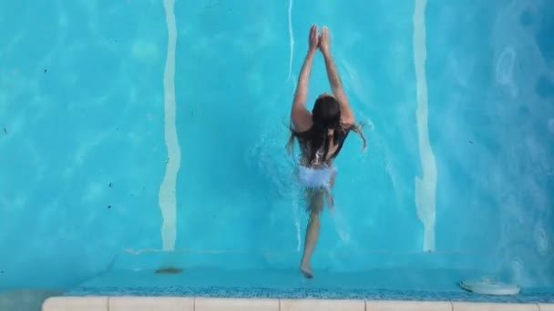 Young woman enjoys swimming in the cool water of a pool in summertime — Stock Video