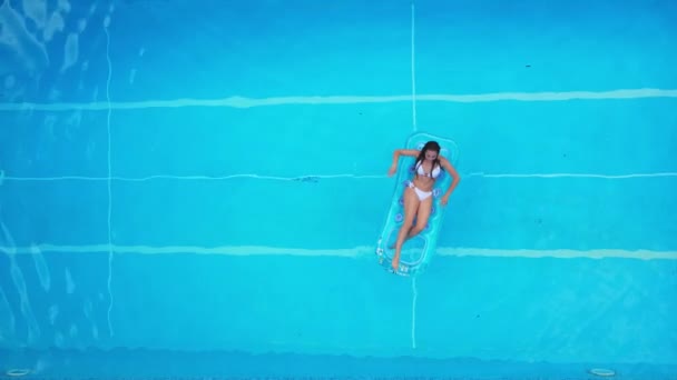 Jolie fille se trouve sur un matelas gonflable dans la piscine — Video