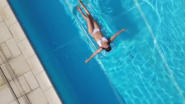 Pretty girl lies on an air mattress in the swimming pool — Stock Video