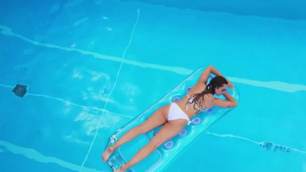 Chica bonita se encuentra en un colchón de aire en la piscina — Vídeos de Stock