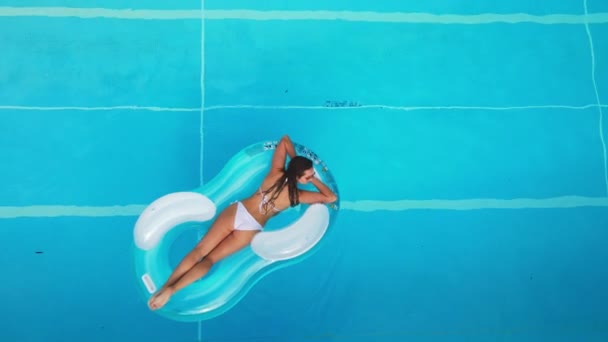Sexy Mädchen genießt die Sonne im kristallklaren Wasser eines Schwimmbades — Stockvideo