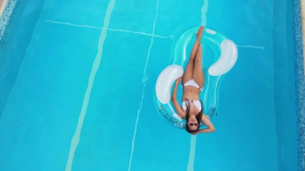 Młoda i seksowna kobieta relaksuje się w basenie latem — Wideo stockowe
